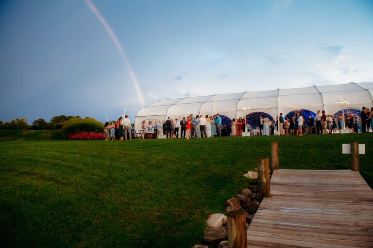 wedding cocktail hour with rainbow and tent at Herrington on the Bay