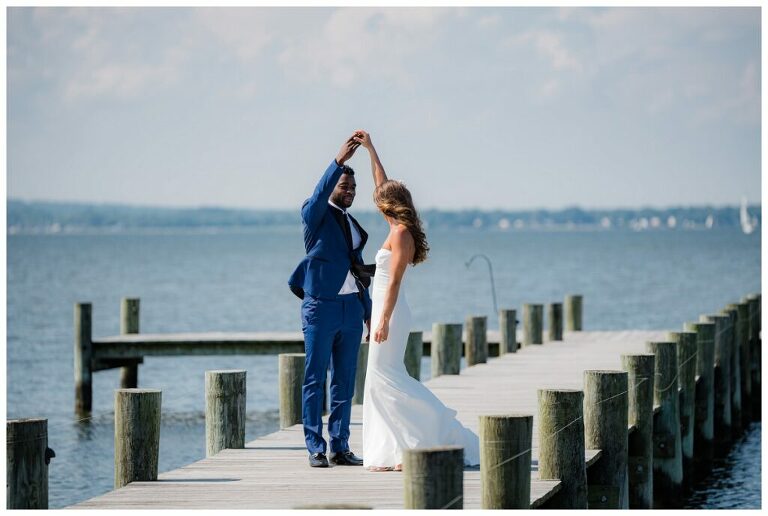 bride and groom in blue suite dancing on pier at Herrington on the Bay Annapolis waterfront wedding