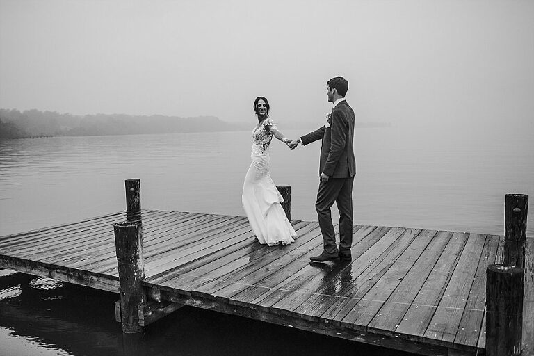 black and white stormy wedding photo on pier in water moody
