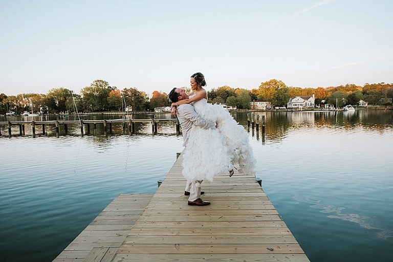 wedding bride and groom on pier at water ruffled dress and white suit at Kent Island Resort